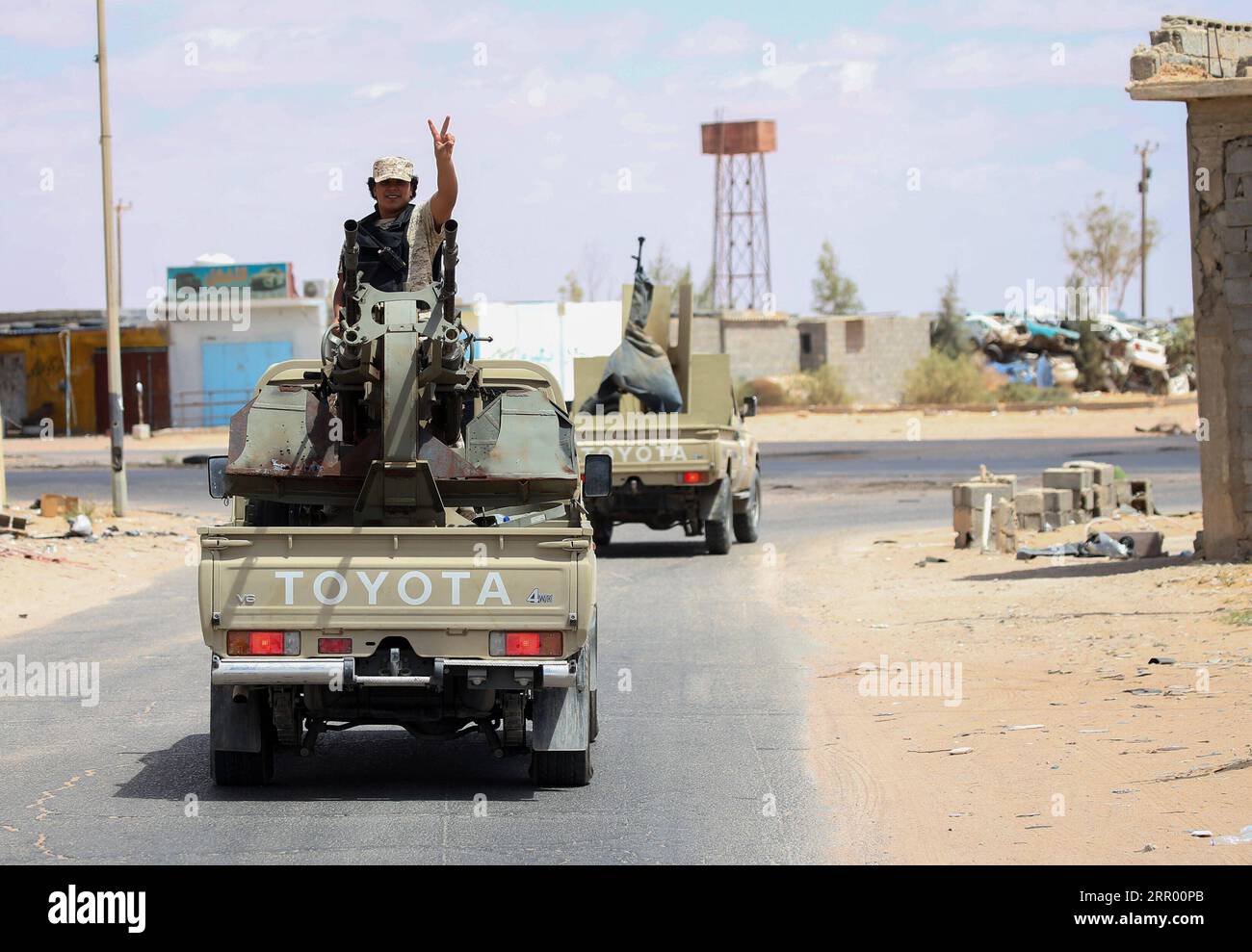 200721 -- TRIPOLI, July 21, 2020 Xinhua -- A fighter of the UN-recognized Libyan government gestures on a pickup truck in the Abu Qurain area about 300 kilometers east of the Libyan capital Tripoli, July 20, 2020. The United Nations is concerned about the military buildup around the northern Libyan port city of Sirte and its potential impact on the civilian population, said Stephane Dujarric, spokesman for UN Secretary-General Antonio Guterres, on Monday. Forces of the UN-recognized Libyan government and the east-based Libyan National Army LNA led by Khalifa Haftar were fighting for the contro Stock Photo