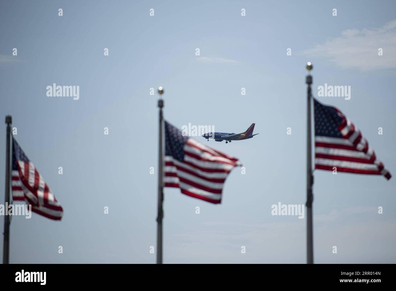 200721 -- WASHINGTON, July 21, 2020 -- A plane flies in the sky with the U.S. national flags in the foreground in Washington, D.C., the United States, on July 21, 2020. U.S. President Donald Trump said Tuesday afternoon that the coronavirus pandemic in the United States will probably get worse before it gets better. More than 3.8 million people in the United States have infected with the virus, with more than 141,000 deaths, according to a count by Johns Hopkins University, as some states, including Florida, are seeing a surge in cases.  U.S.-WASHINGTON, D.C.-TRUMP-CORONAVIRUS PANDEMIC LiuxJie Stock Photo