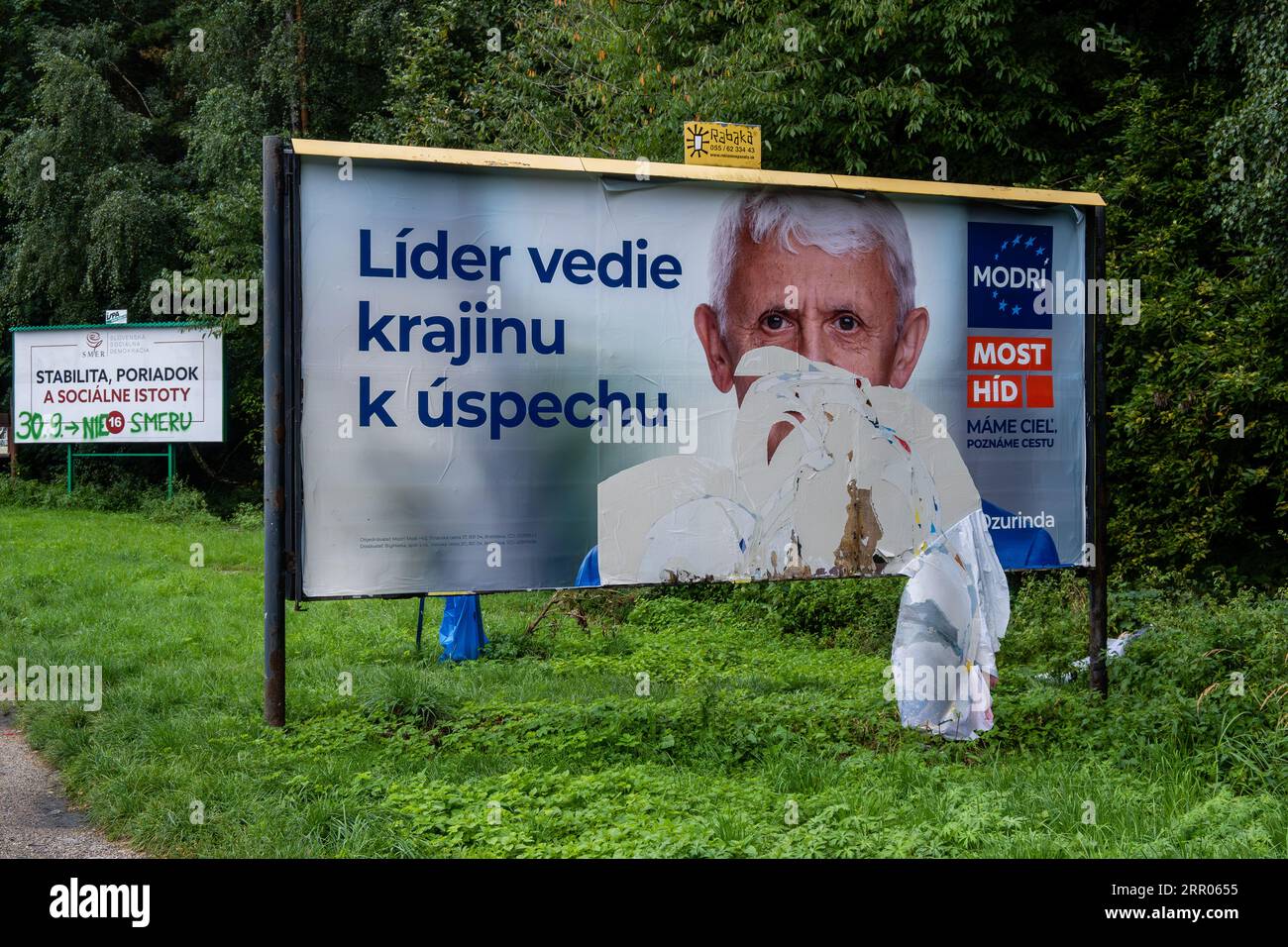 The election billboard for the Modri Most-Hid party displays the face of the leader of the party and former prime minister Mikulas Dzurinda (right) and the election billboard for Smer party (left), which is lead by former prime minister Robert Fico in the street in Sutovo. Slovakia will hold its parliament elections on September 30, 2023. According to current election polls, winner of election would be Smer party with election leader Robert Fico, former prime minister, followed by liberal party Progresivne Slovensko with leader Michal Simecka, Vice-President of the European Parliament, followe Stock Photo