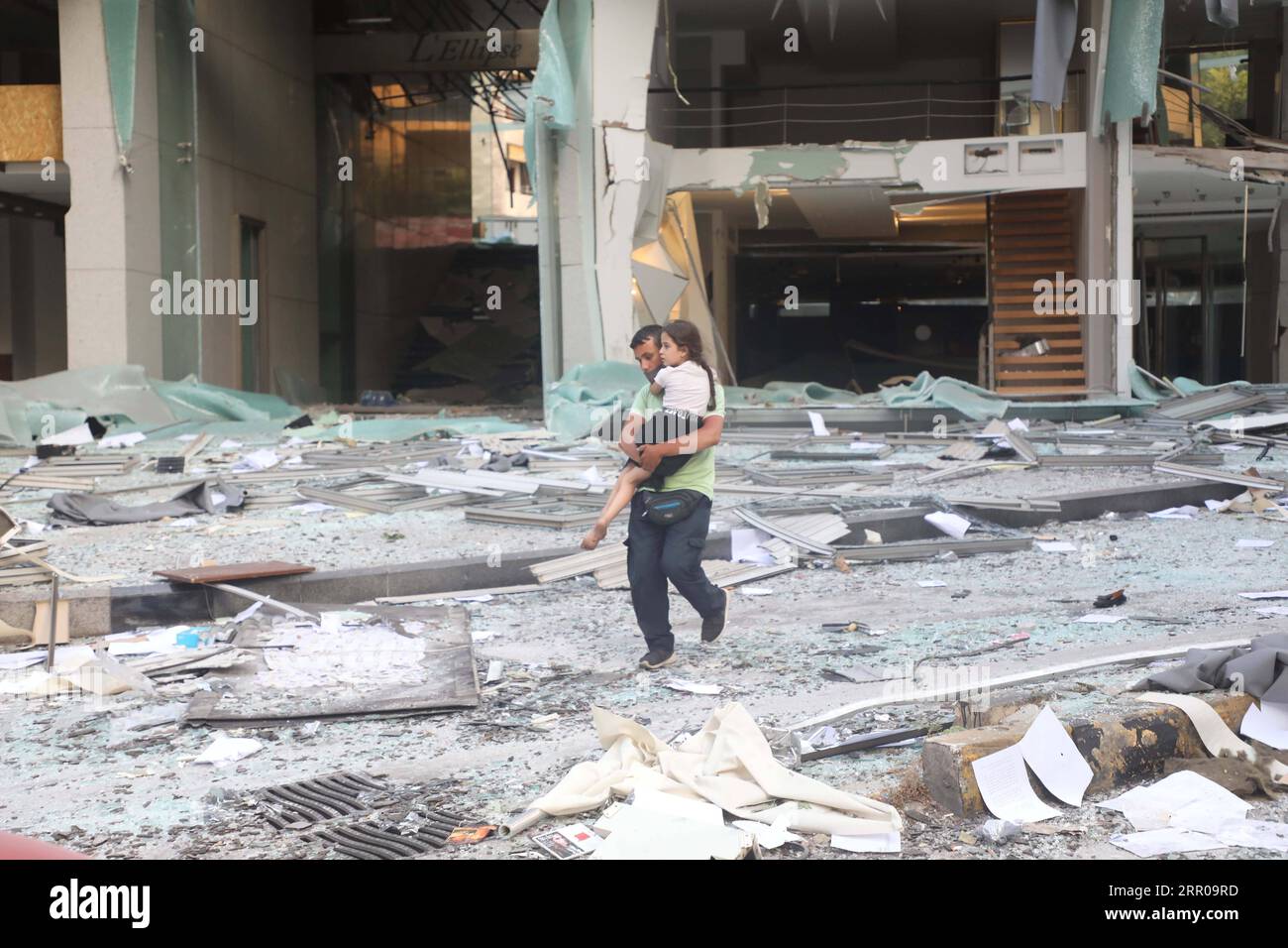 News Bilder des Tages 200804 -- BEIRUT, Aug. 4, 2020 Xinhua -- A man carrying a child walks past a damaged building after the explosion in Beirut, Lebanon, Aug. 4, 2020. The two huge explosions that rocked Lebanon s capital Beirut on Tuesday left dozens dead and injured, al-Jadeed TV channel reported. Xinhua/Bilal Jawich LEBANON-BEIRUT-HUGE EXPLOSIONS PUBLICATIONxNOTxINxCHN Stock Photo
