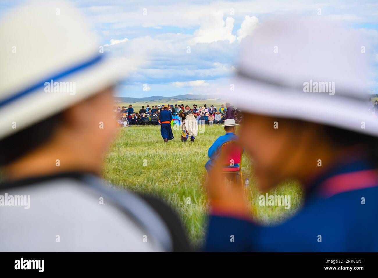 200809 -- XILIN GOL, Aug. 9, 2020 -- Xilinhua R and a friend watch a wrestling match during a Naadam event held on the Baiyinxile grassland in Xilinhot, north China s Inner Mongolia Autonomous Region, Aug. 3, 2020. Summer vationtion has been Xilinhua s favorite time of year. In order to attend middle school, the 14-year-old lives most of the time with her grandparents in downtown Xilinhot, separated from her parents who run a ranch on the Baiyinxile pasture. Therefore, summer means both relaxation and reunion to the seventh grader. Xilinhua s father Gangsuhe is a famous horse rider. Learning f Stock Photo