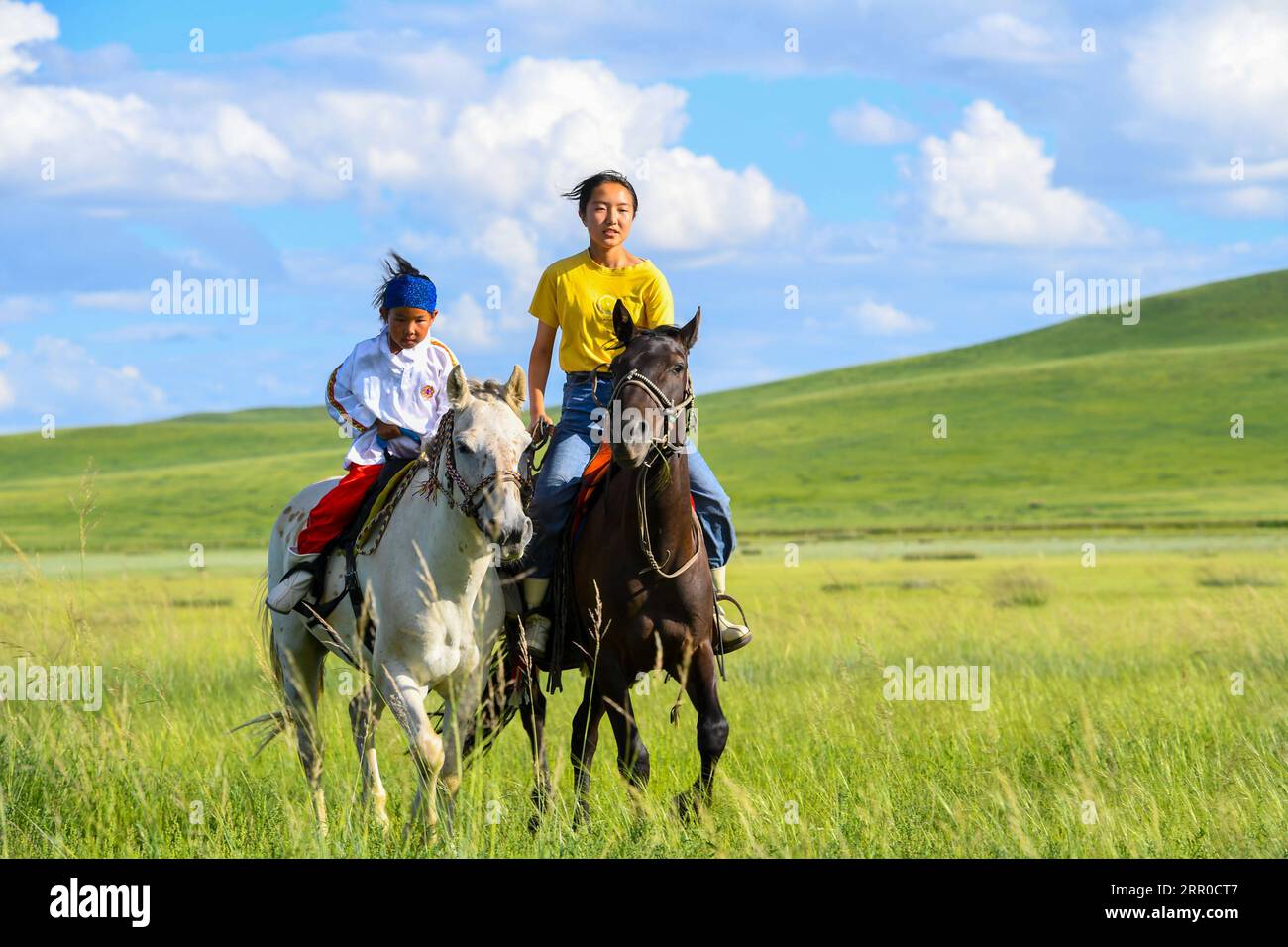 200809 -- XILIN GOL, Aug. 9, 2020 -- Xilinhua R and a friend ride horses on the Baiyinxile grassland in Xilinhot, north China s Inner Mongolia Autonomous Region, Aug. 4, 2020. Summer vationtion has been Xilinhua s favorite time of year. In order to attend middle school, the 14-year-old lives most of the time with her grandparents in downtown Xilinhot, separated from her parents who run a ranch on the Baiyinxile pasture. Therefore, summer means both relaxation and reunion to the seventh grader. Xilinhua s father Gangsuhe is a famous horse rider. Learning from him, Xilinhua had also mastered equ Stock Photo