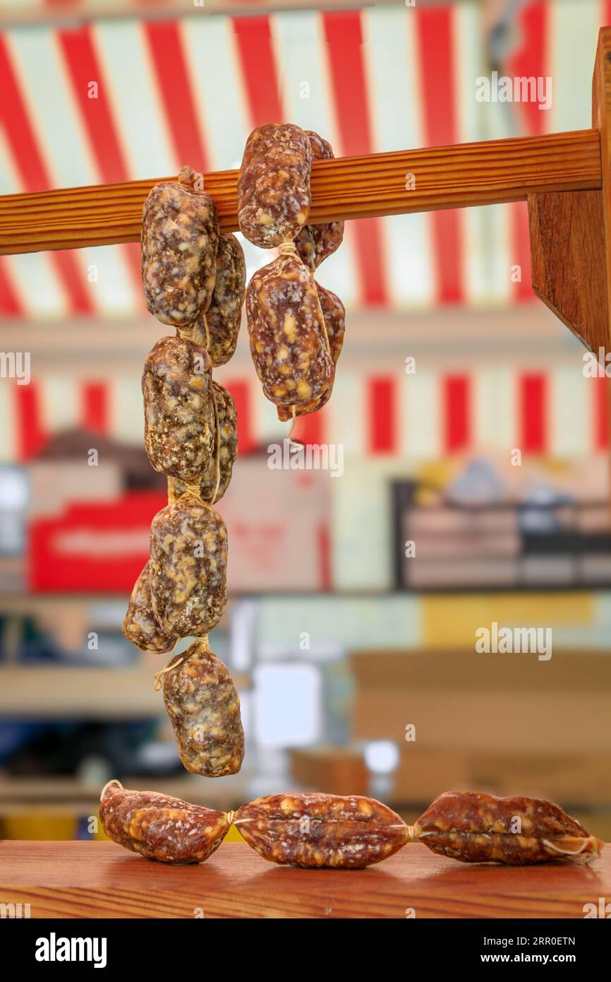 Artisanal pork sausages hanging, on display at a local farmers market ...