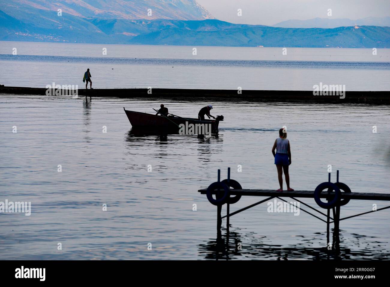 200814 SKOPJE Aug. 14 2020 Xinhua People enjoy their time at a dock on the shore of Ohrid Lake in Struga North Macedonia on Aug. 13 2020. The number of