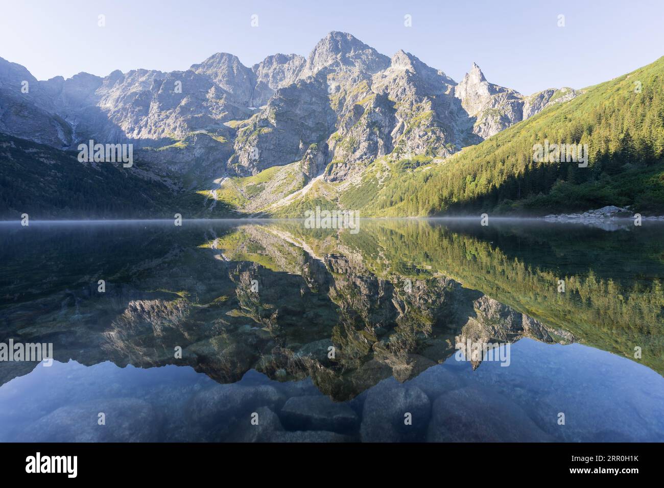 Majestic rocky mountain reflecting in pristine crystal clear alpine lake, Poland, Europe Stock Photo
