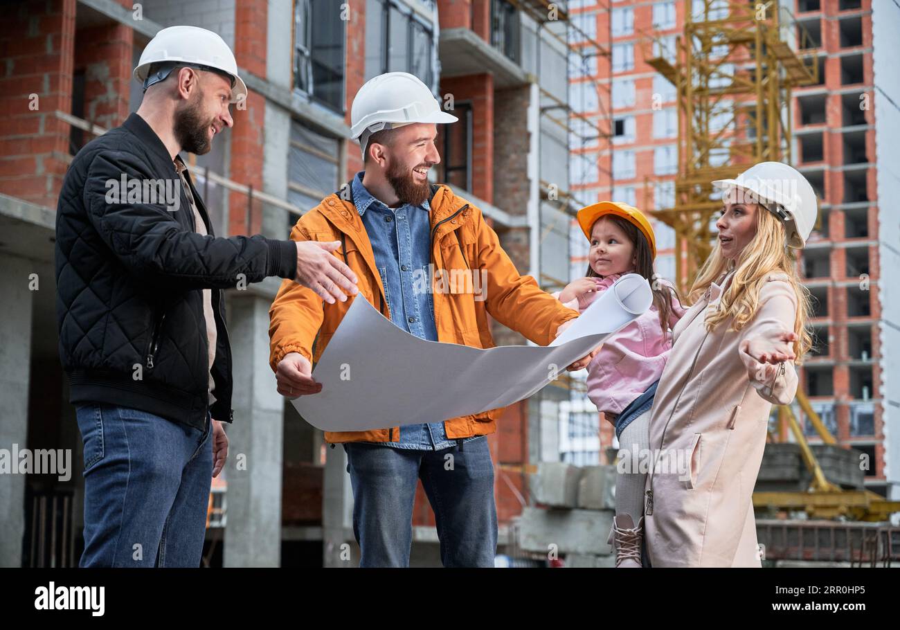 Contruction Project Parents Happy family with child discussing architectural building plan with ...