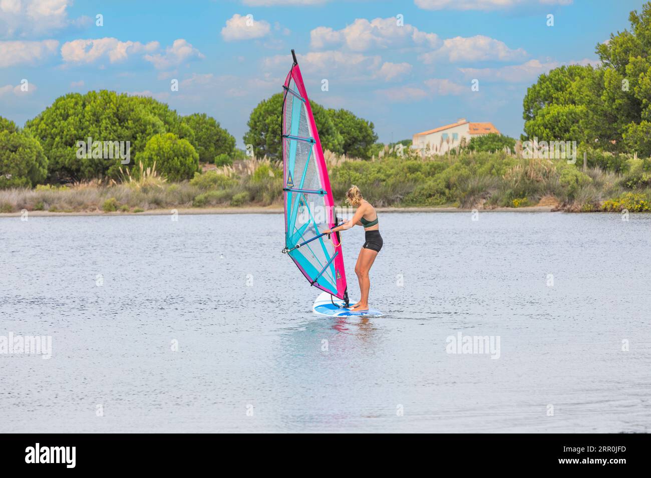 A young woman windsurfer on an Etang near to Le Barcares, South of France Stock Photo