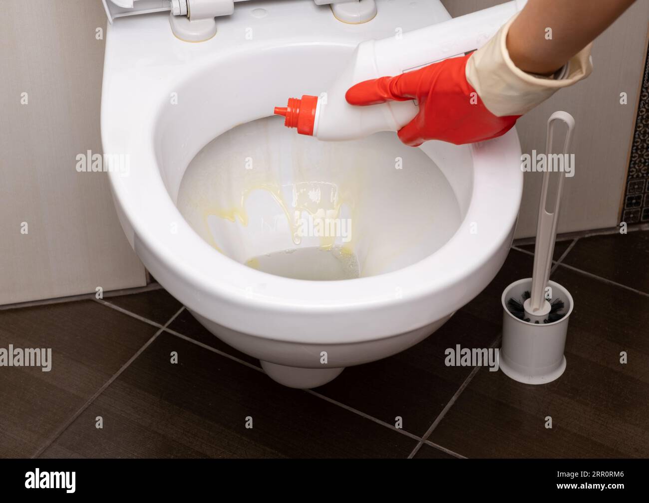Woman in red rubber gloves cleaning toilet Stock Photo Alamy