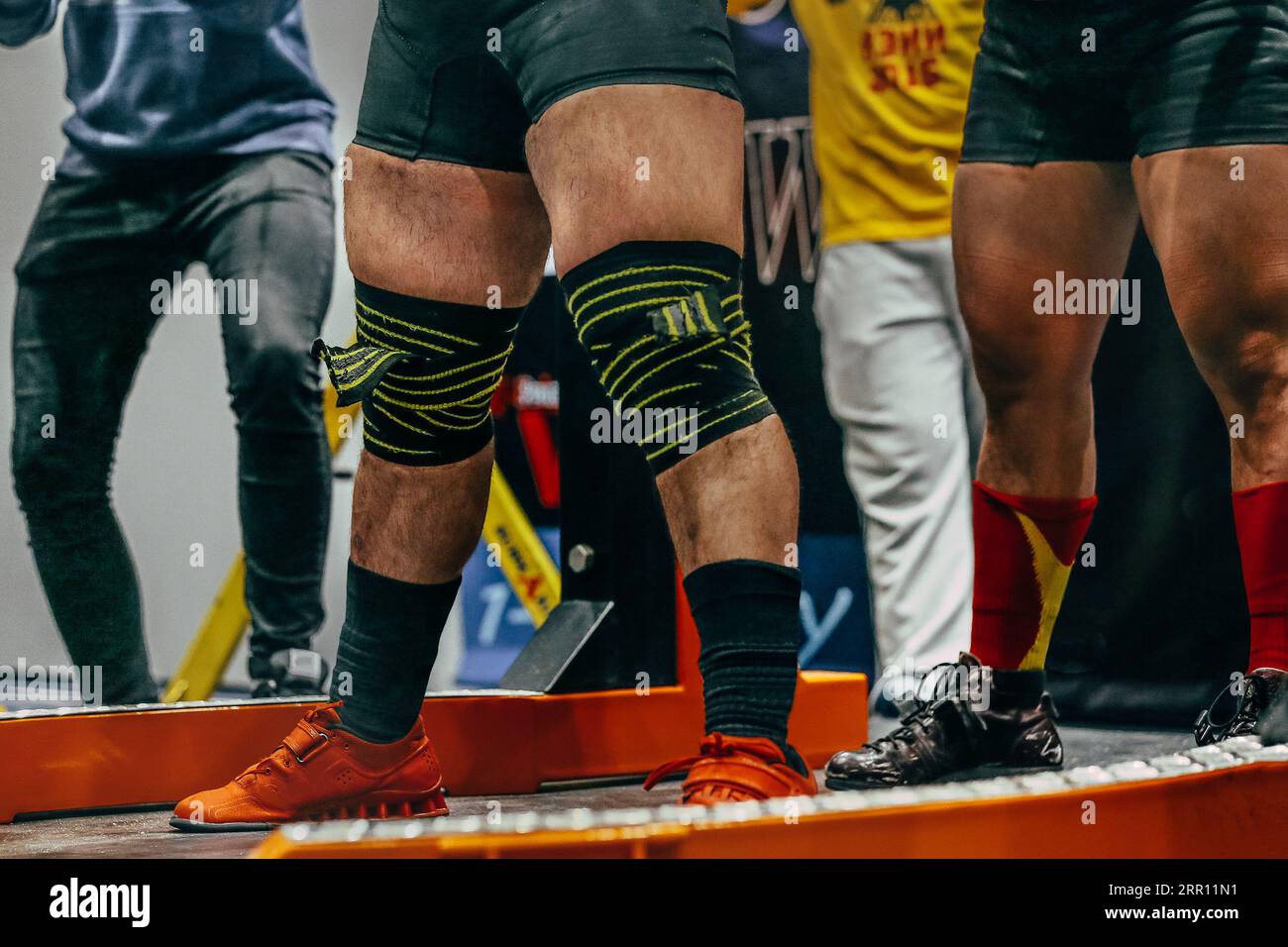 male powerlifter preparing for squat powerlifting, knees are wrapped with an elastic bandage Stock Photo