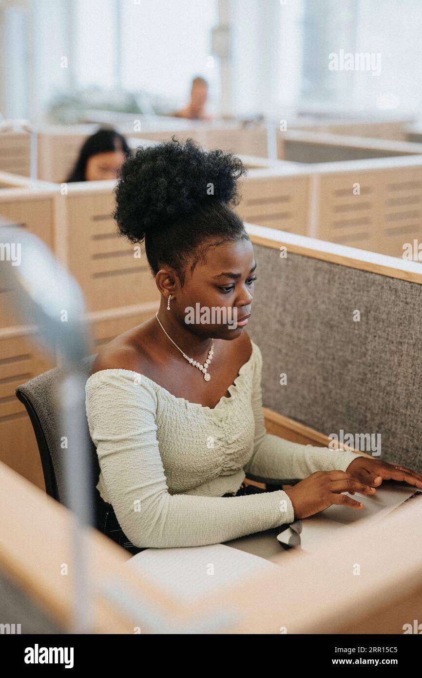 Young woman using laptop while studying at university Stock Photo