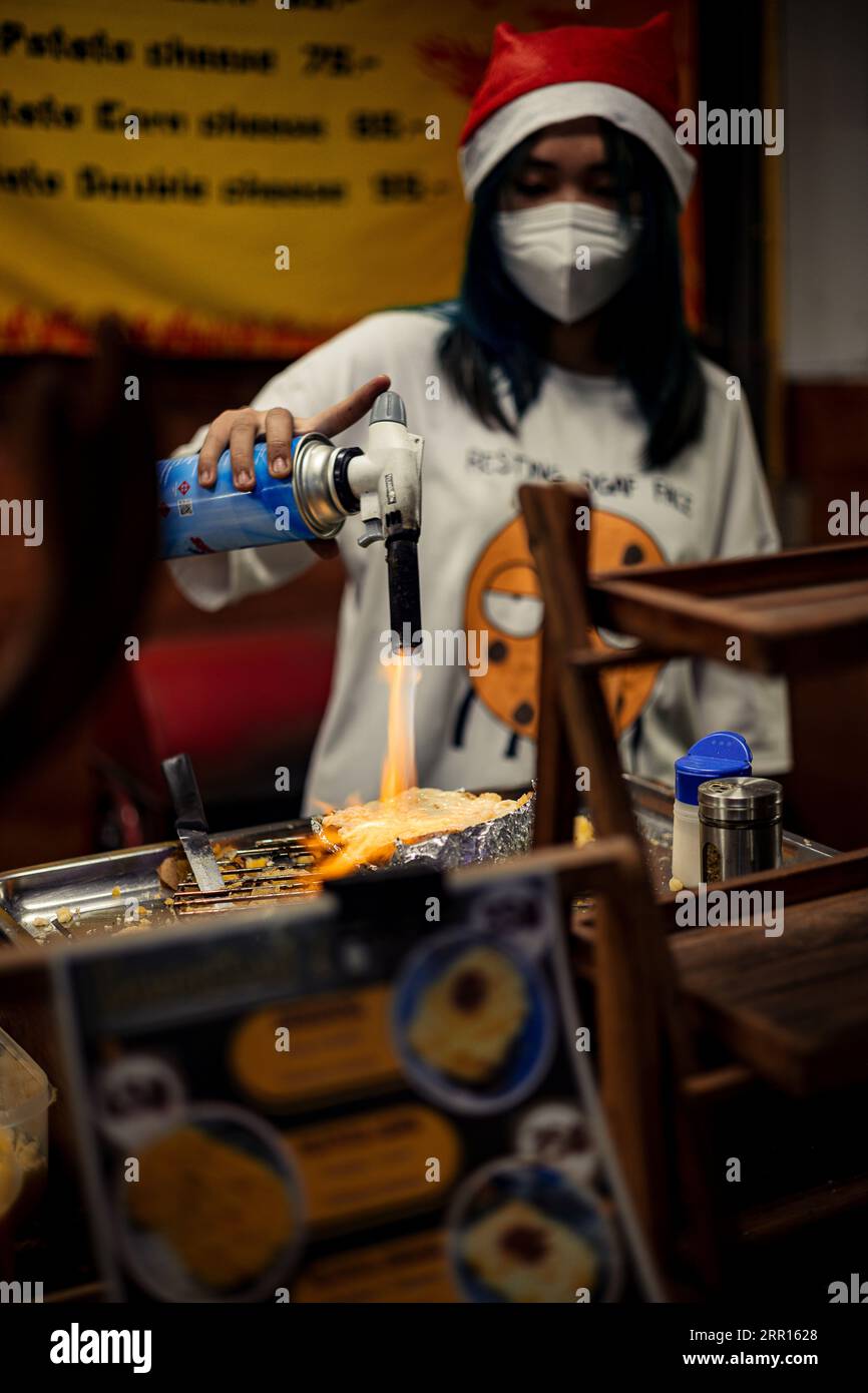 Melting cheese on a potato with a torch Stock Photo Alamy