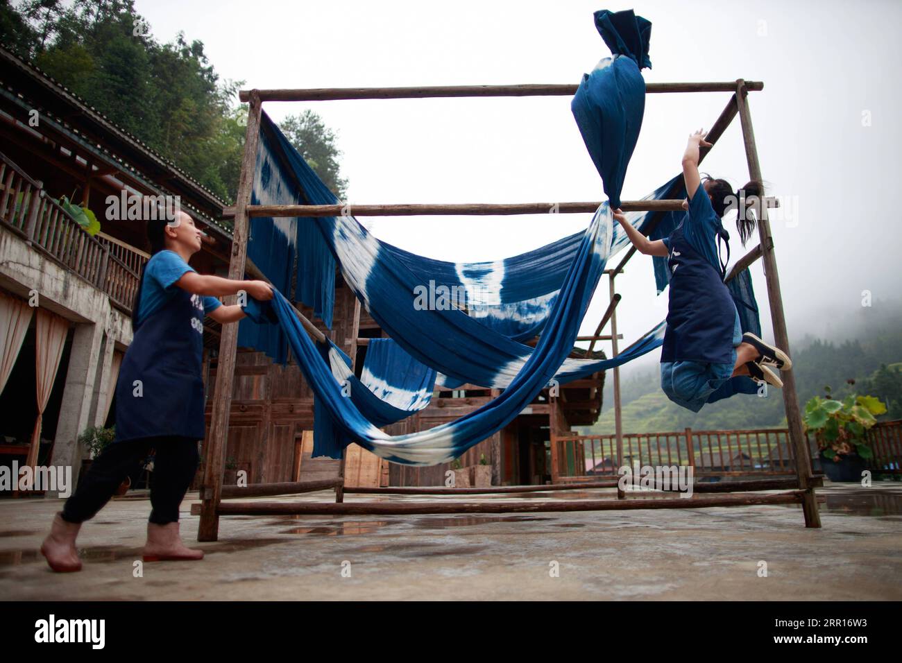 200907 -- RONGJIANG, Sept. 7, 2020 -- Two women dry cloth at a workshop in Fengdeng Dong Village of Rongjiang County, southwest China s Guizhou Province, Sept. 6, 2020. Locals take advantage of the favorable autumn weather conditions to make the traditional cloth of Dong ethnic group.  CHINA-GUIZHOU-DONG VILLAGE-CLOTH MAKING CN LiuxXu PUBLICATIONxNOTxINxCHN Stock Photo