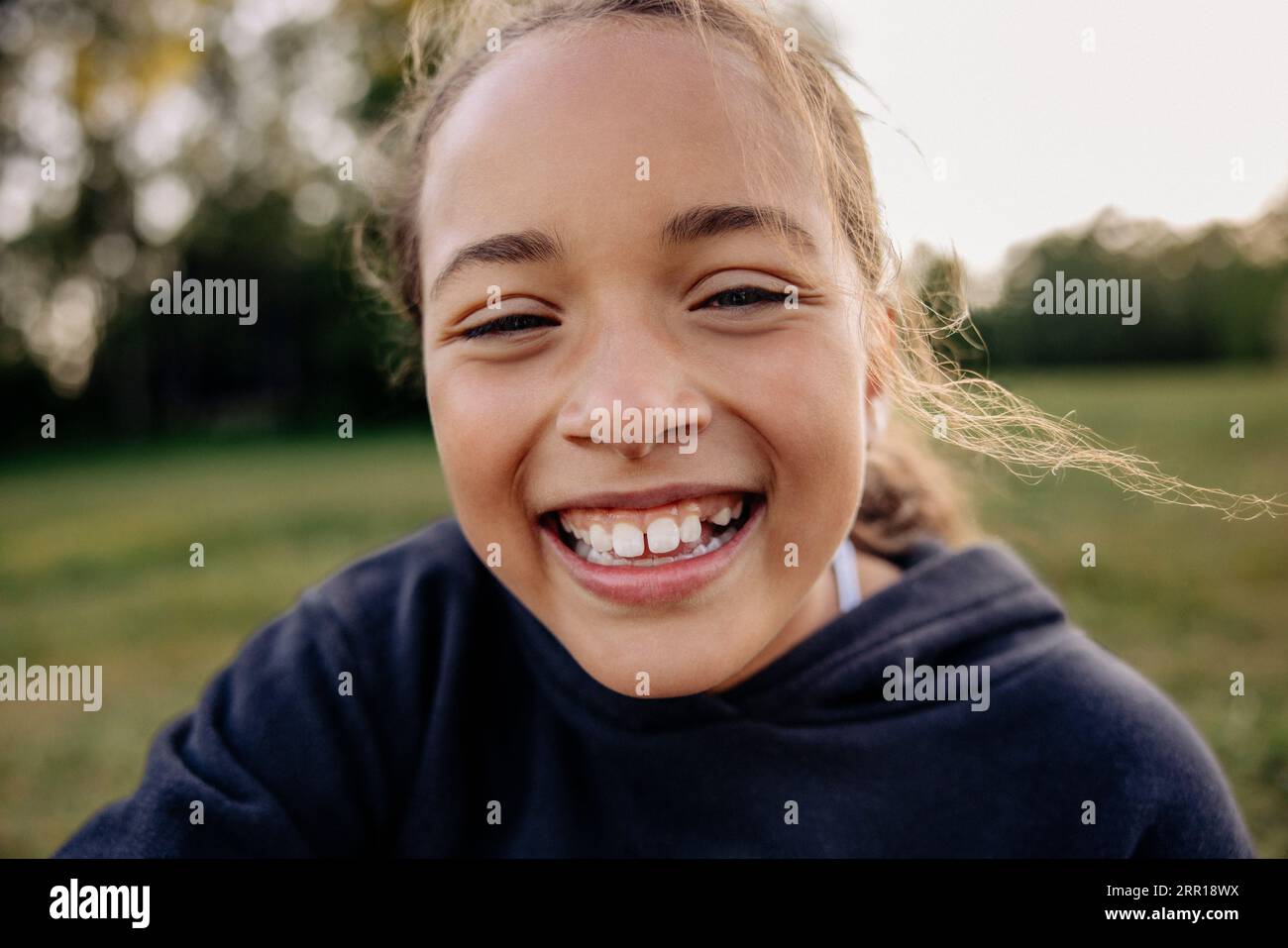 Portrait of happy girl laughing in playground Stock Photo