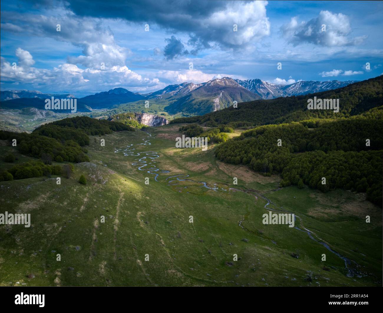 An aerial view of a river flowing through green mountains Stock Photo ...