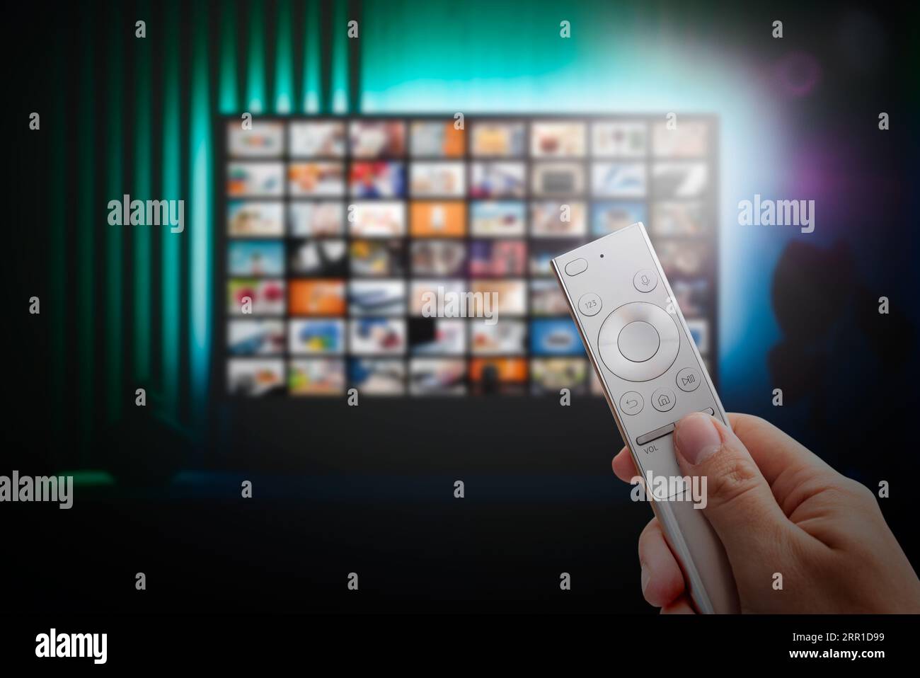 VOD service screen. Man watching TV with remote control in hand. Stock Photo