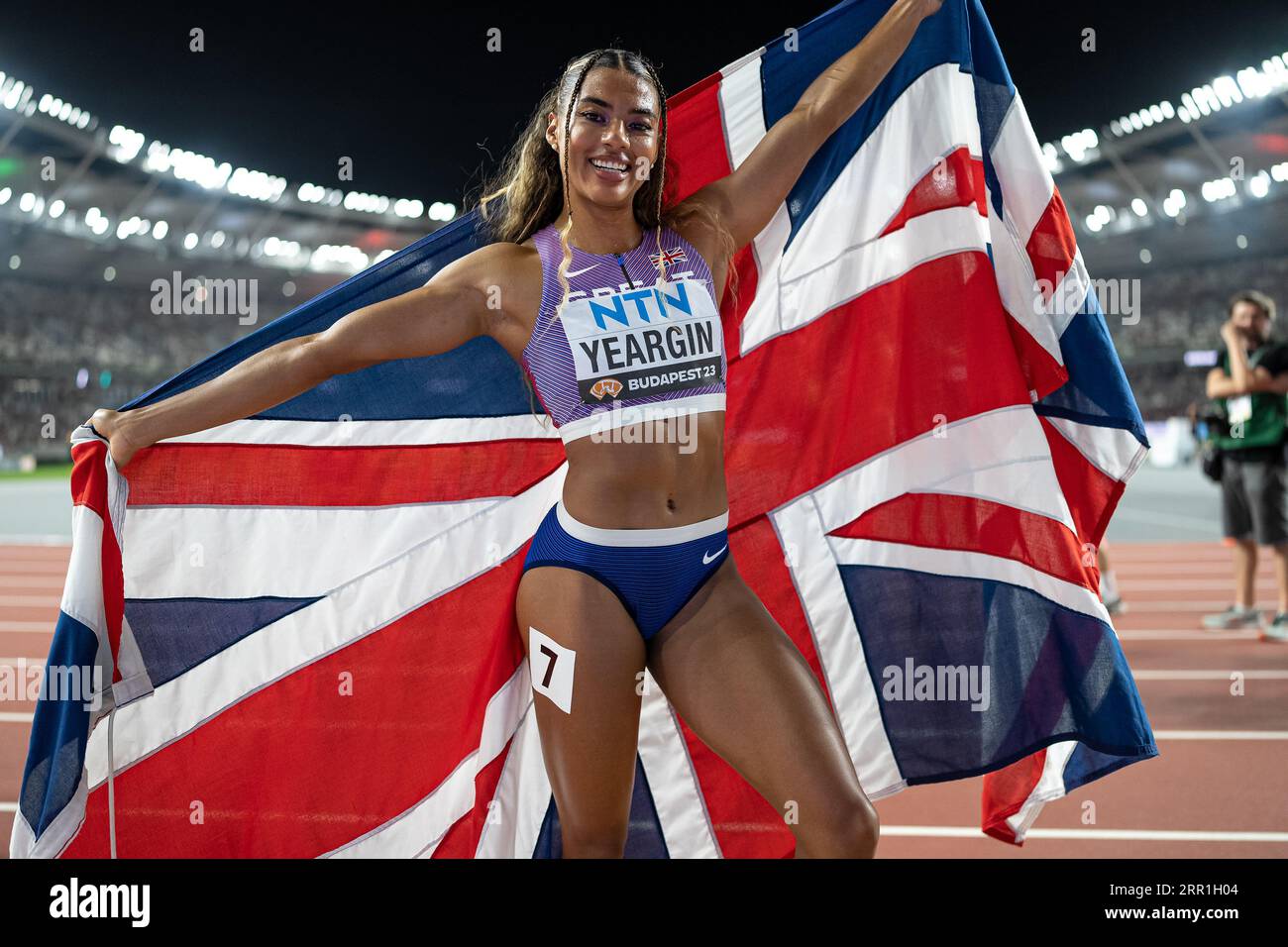 Nicole yeargin celebrating her medal with her country s flag in the
