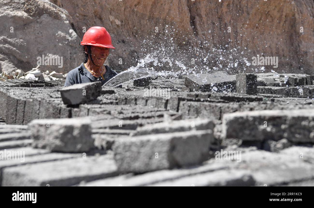 200920 -- LHASA, Sept. 20, 2020 -- An employee from a registered impoverished household works at a cement brick factory near the Xiba poverty-relief relocation site in Baxoi County, Qamdo, southwest China s Tibet Autonomous Region, Sept. 19, 2020. A cement brick factory near the Xiba poverty-relief relocation site in Baxoi County has offered vocational training and job opportunities to residents from 657 registered impoverished households. Since April, nearly 200 people have attended brick-making training sessions here.  CHINA-TIBET-QAMDO-POVERTY ALLEVIATION CN JigmexDorje PUBLICATIONxNOTxINxC Stock Photo