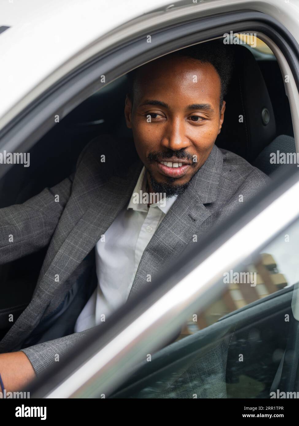 From above of smiling young African American male looking away while