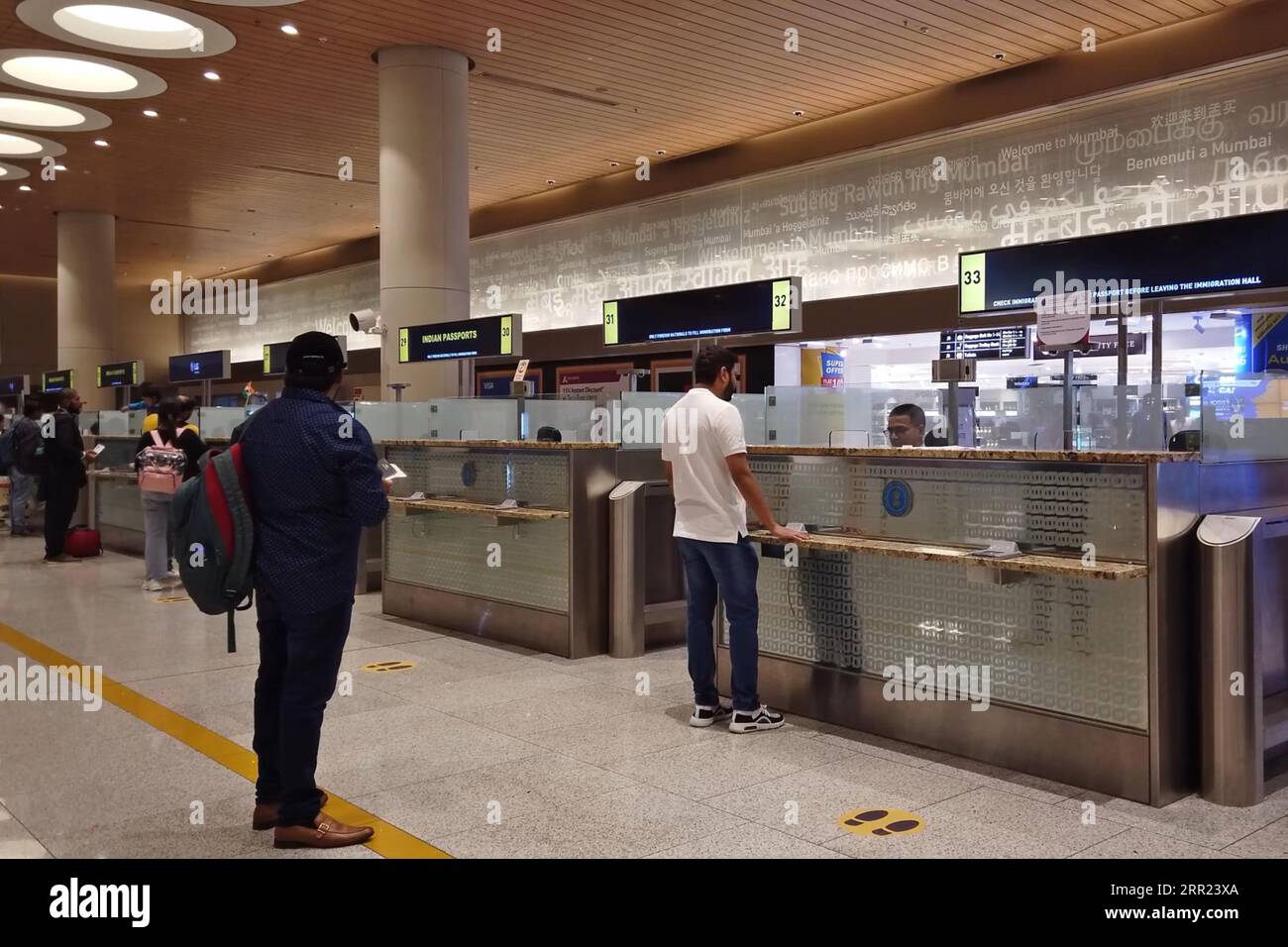 Passengers pass through passport control desks at the arrival hall of ...