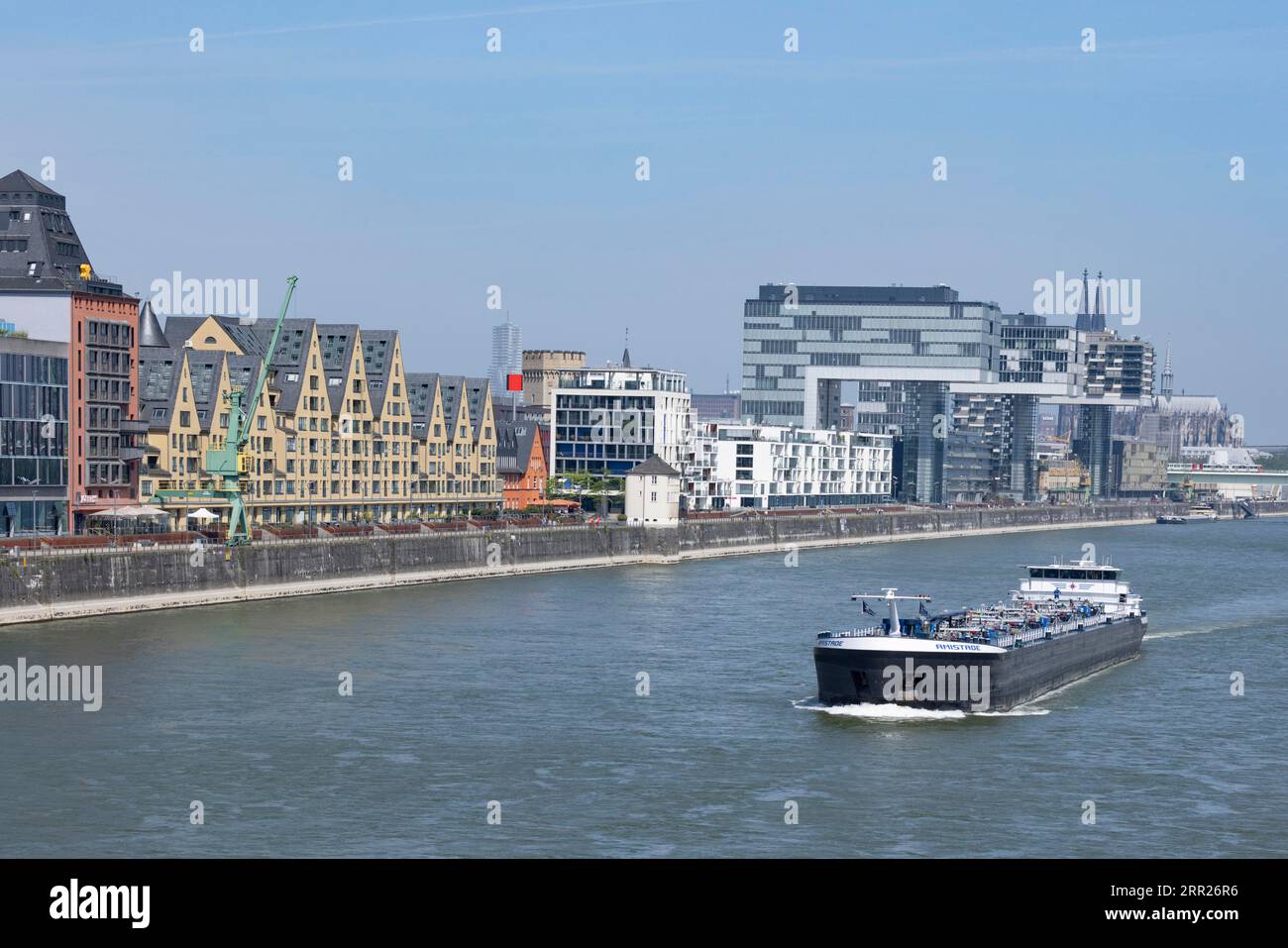 Cargo ship on the Rhine in front of Cologne's Rheinauhafen, cathedral, Severinsbruecke, crane houses, Cologne, North Rhine-Westphalia, Germany Stock Photo