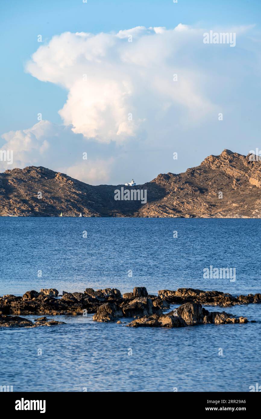 Rocky coast with lighthouse Akrotiri Korakas with blue sea, Paros, Cyclades, Greece Stock Photo