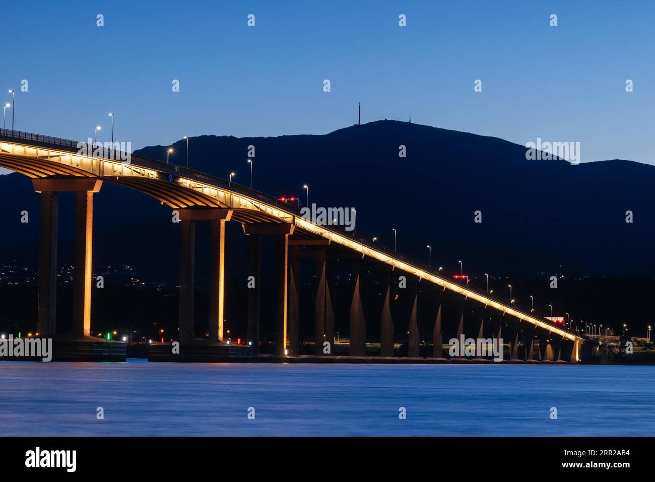 The iconic Tasman Bridge at dusk on a clear spring evening crossing the Derwent RIver in central Hobart, Tasmania, Australia. Shot from the Clarence Stock Photo