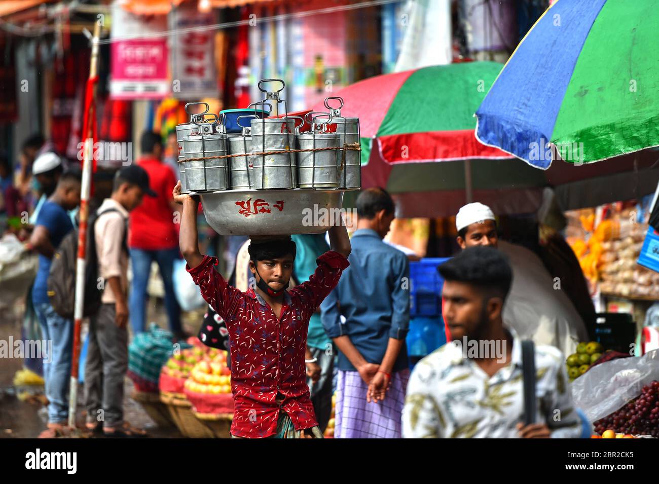 201008 -- DHAKA, Oct. 8, 2020 -- A deliveryman carries lunchboxes on head in Dhaka, Bangladesh, Oct. 8, 2020. Office-goers particularly from the less affluent section in Bangladesh capital Dhaka still prefer to have ready-cooked meals from homes or traditional kitchens through dabbawalas traditional lunchbox deliverymen who now struggle to keep up with today s relatively cheaper food-delivery apps. BANGLADESH-DHAKA-HOME-MADE-MEALS Salim PUBLICATIONxNOTxINxCHN Stock Photo