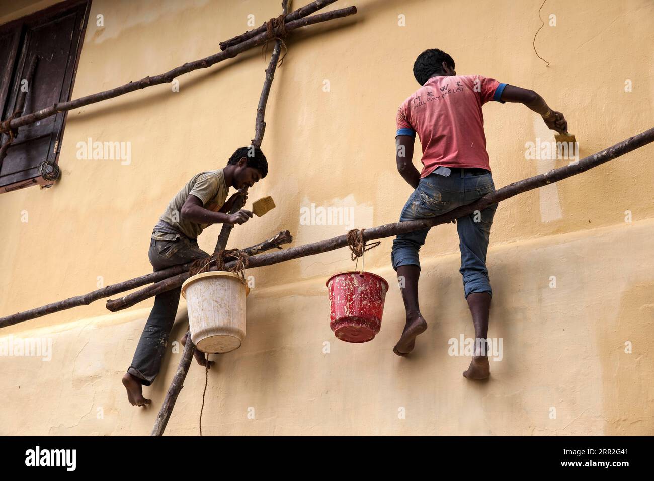 Painters painting a house wall, Fort Kochi, Kochi, Kerala, India Stock