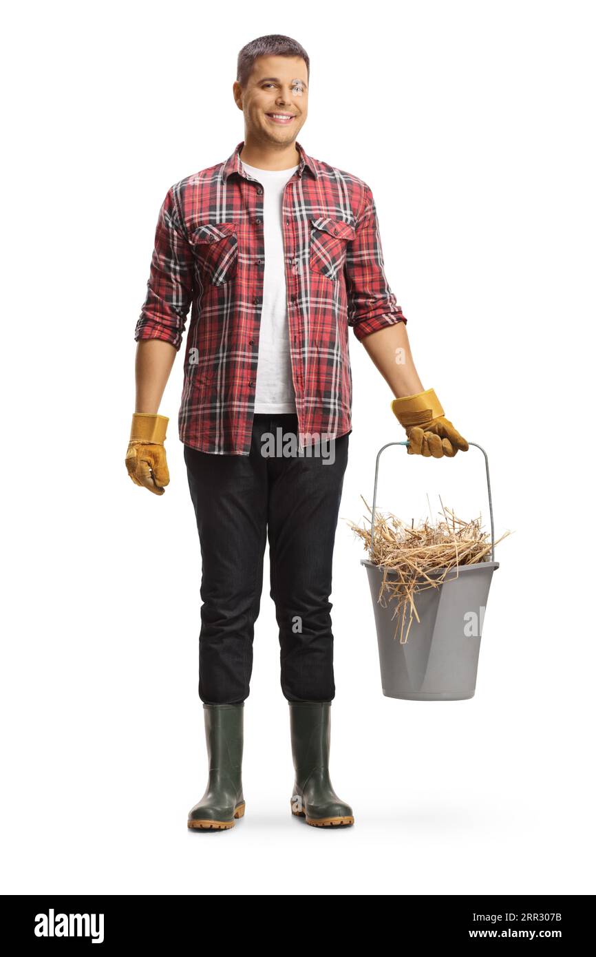 Full length portrait of a farmer holding a bucket with hay isolated on white background Stock Photo