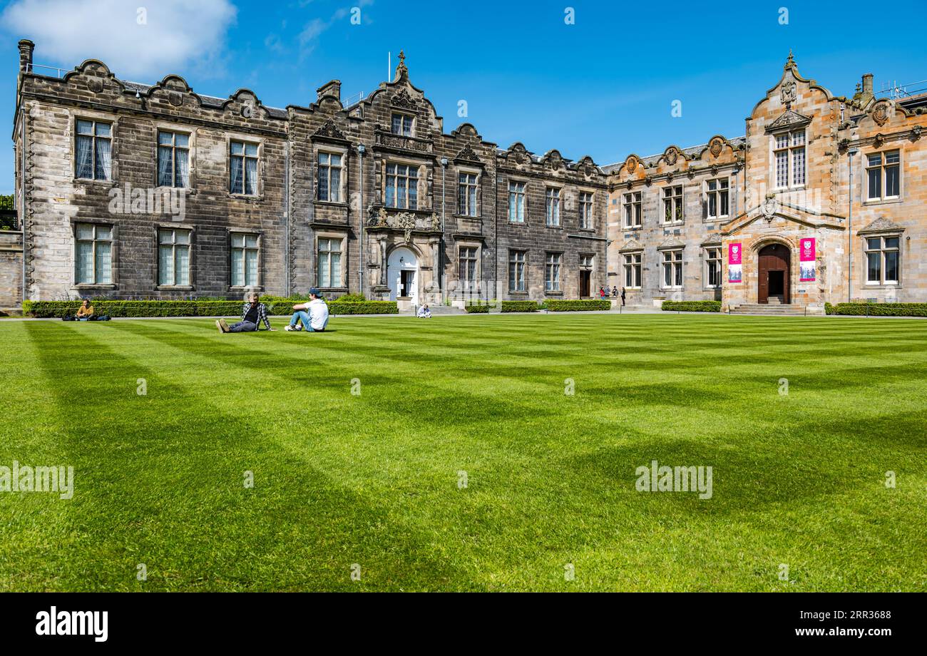 University students relaxing on grass lawn, St Salvator's College Quadrangle, St Andrews University, Fife, Scotland, UK Stock Photo