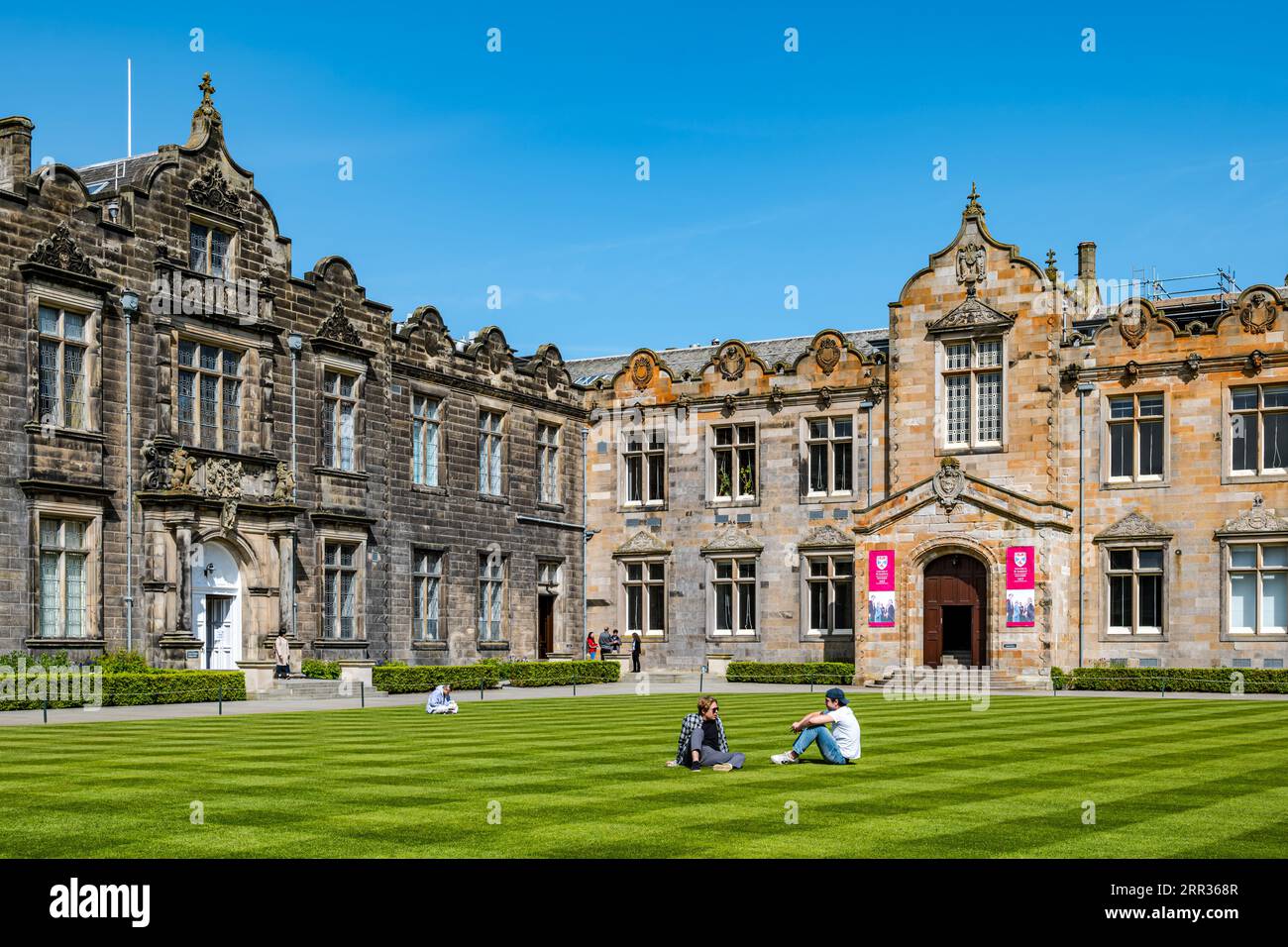 University students relaxing on grass lawn, St Salvator's College Quadrangle, St Andrews University, Fife, Scotland, UK Stock Photo