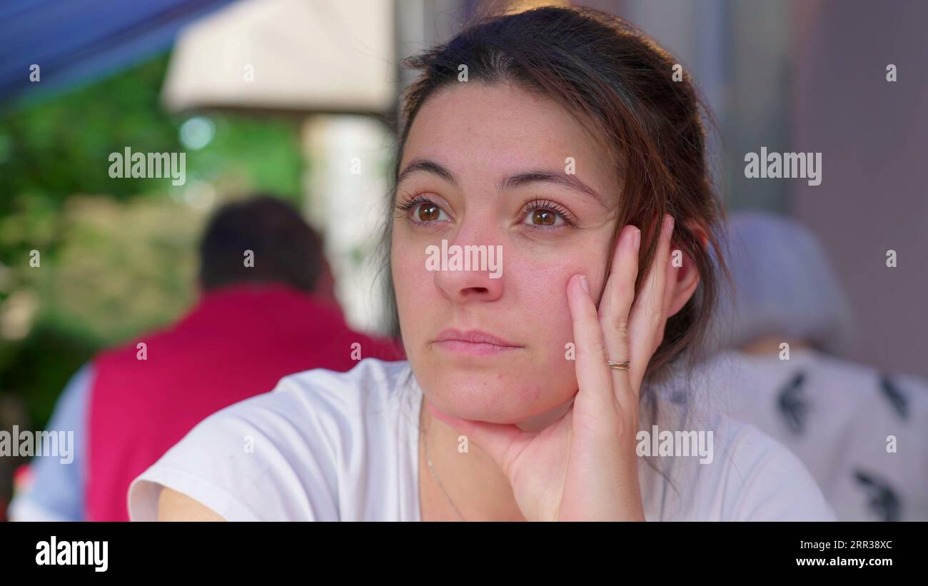 Reflective Woman in Her 30s, Deep in Thought at Restaurant, Awaiting