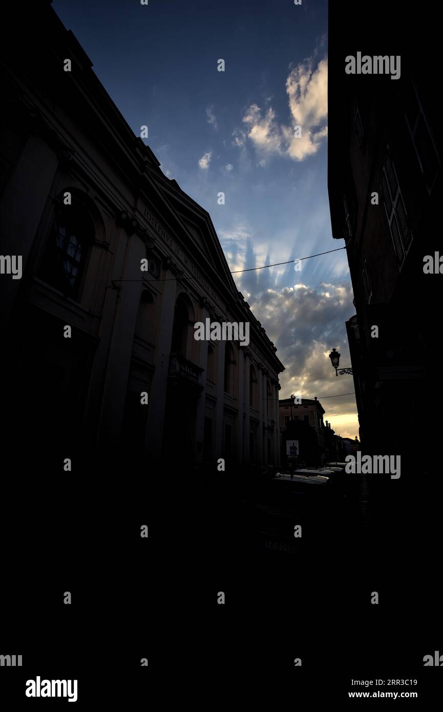 Sunset sky with clouds framed by the buildings of a street Stock Photo ...