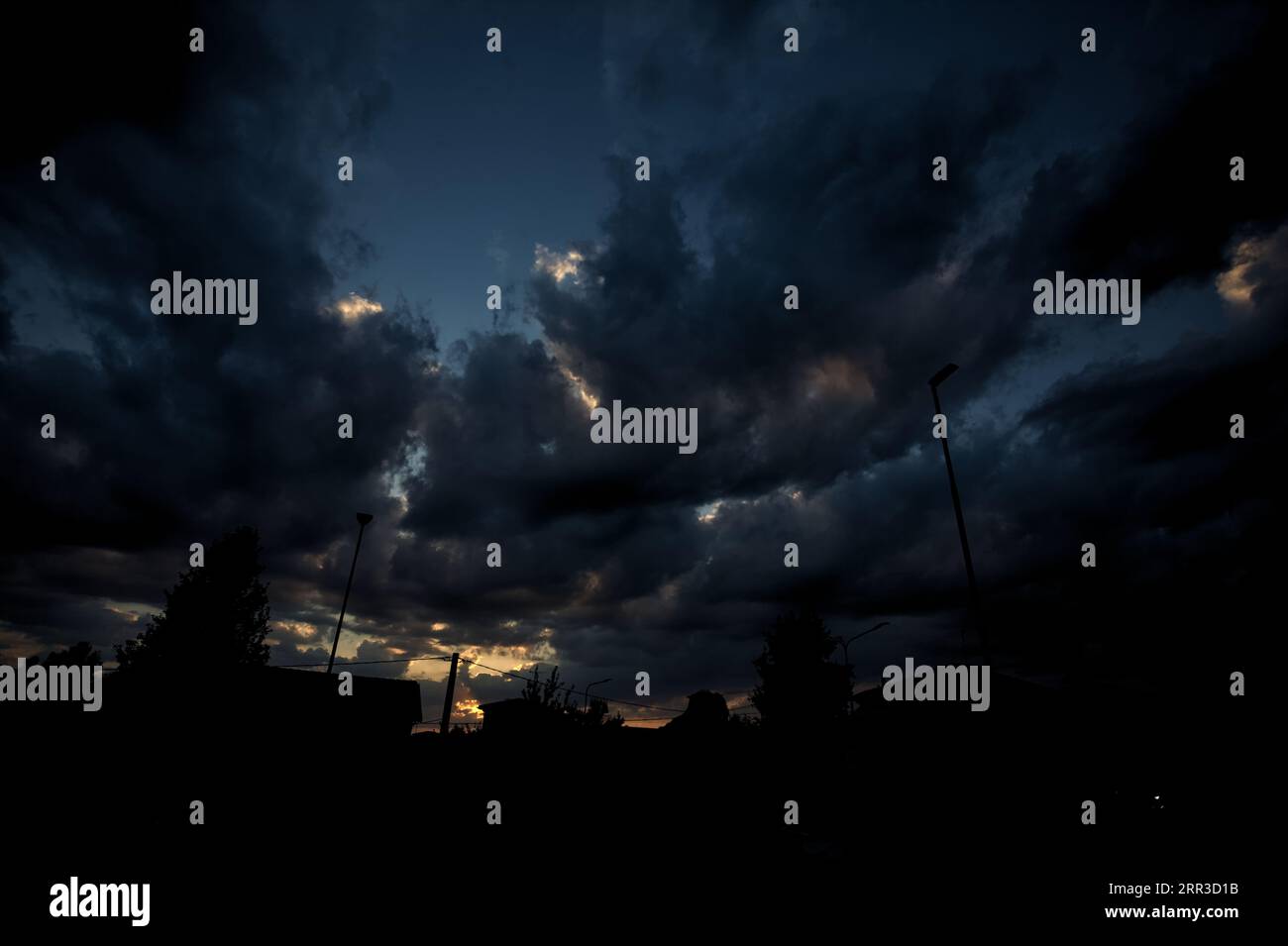 Sunset cloudy sky with silhouette of buildings Stock Photo - Alamy