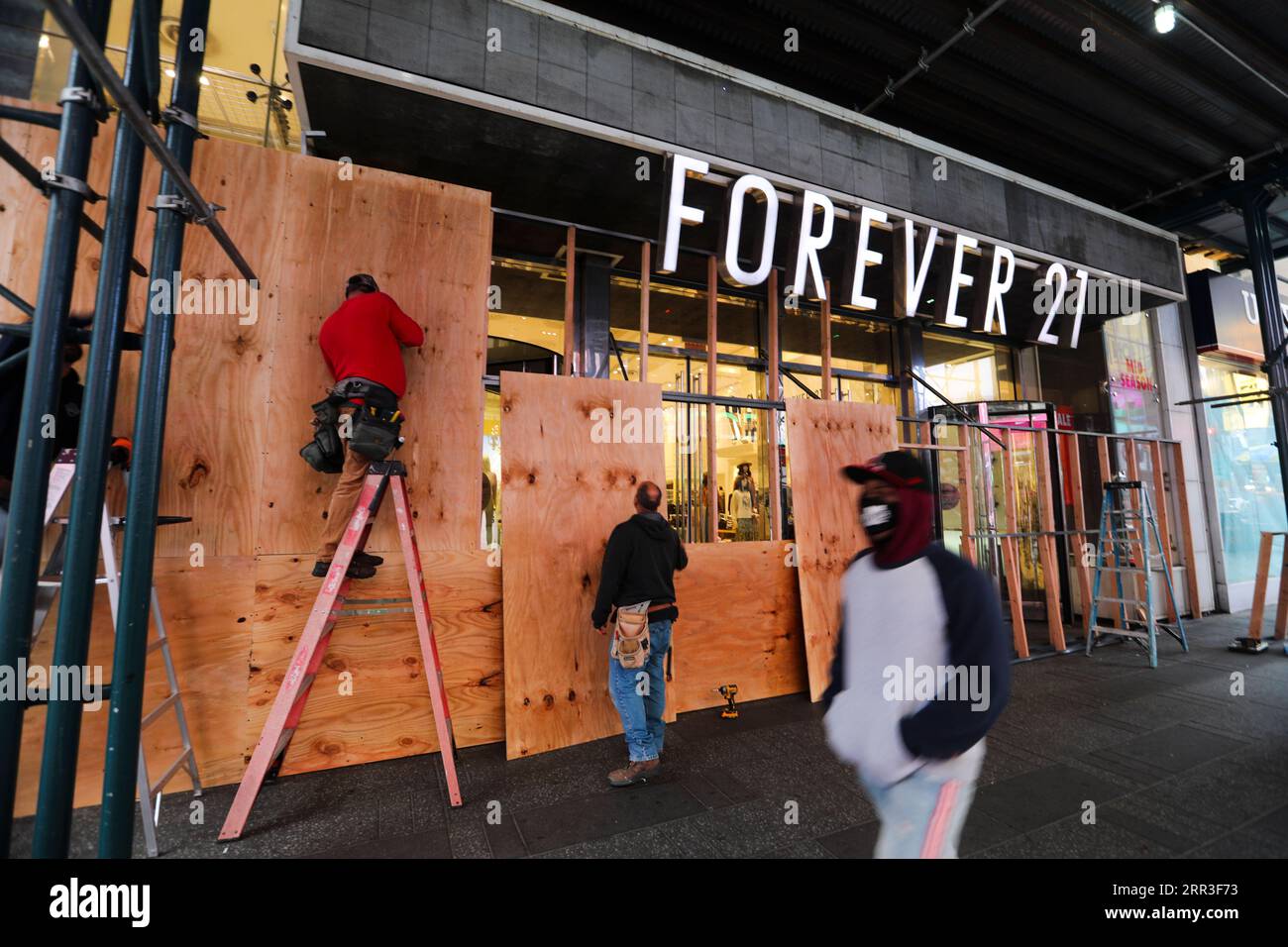 201101 -- NEW YORK, Nov. 1, 2020 -- Workers board up a store in Times Square in New York, the United States, on Nov. 1, 2020. The moves come as retailers are trying to protect themselves against looting or other civil unrest in the coming days.  U.S.-NEW YORK-STORES-BOARDING UP WangxYing PUBLICATIONxNOTxINxCHN Stock Photo