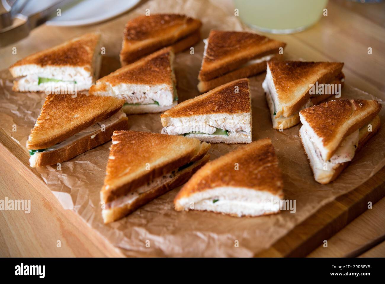 https://c8.alamy.com/comp/2RR3FYB/sandwiches-with-cheese-chicken-meat-and-cucumber-on-a-wooden-tray-catering-sandwich-display-2RR3FYB.jpg