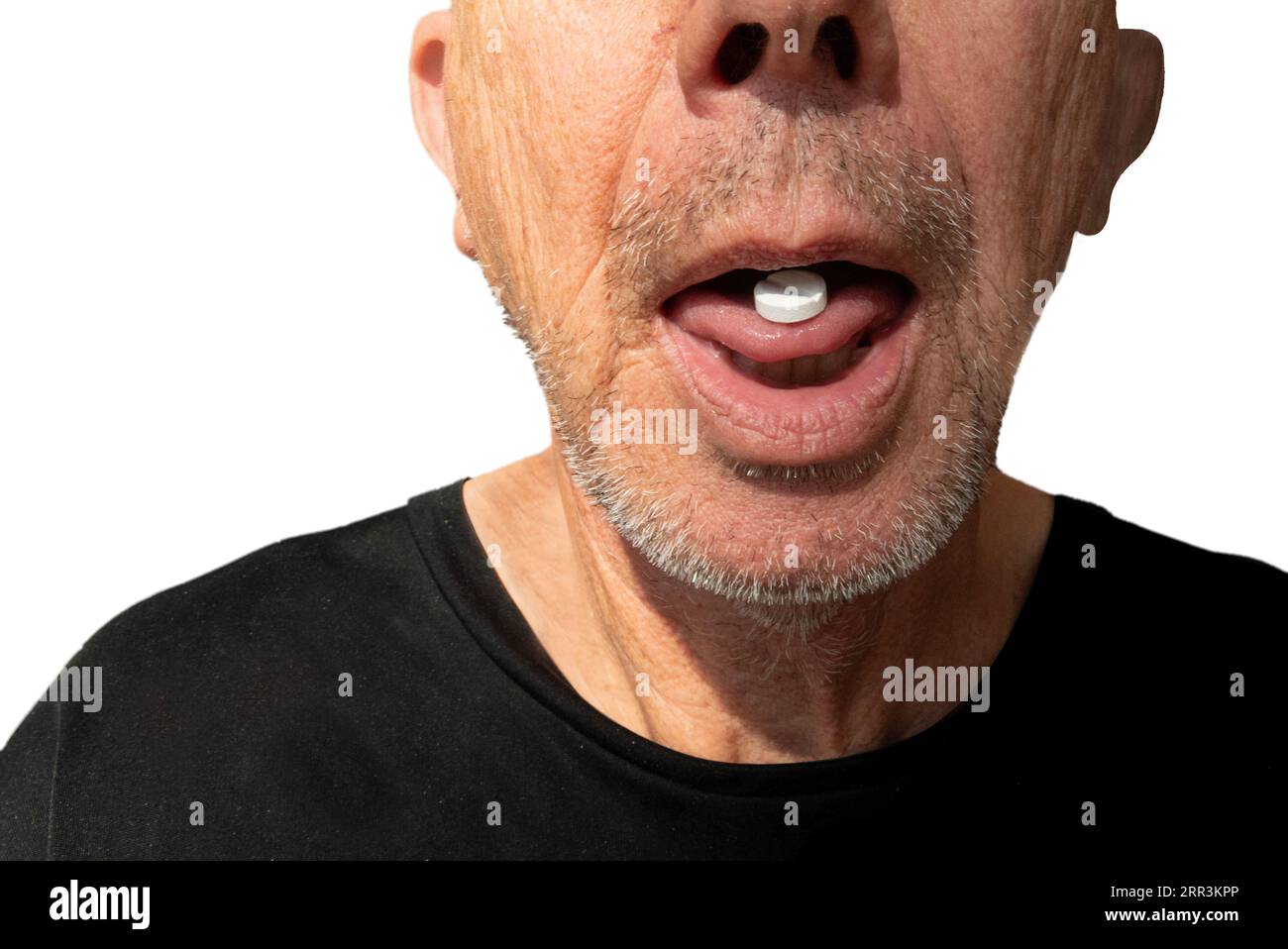 Man takes medication. White pill on tongue on mature man with stubble. Close up image isolated on white. Stock Photo