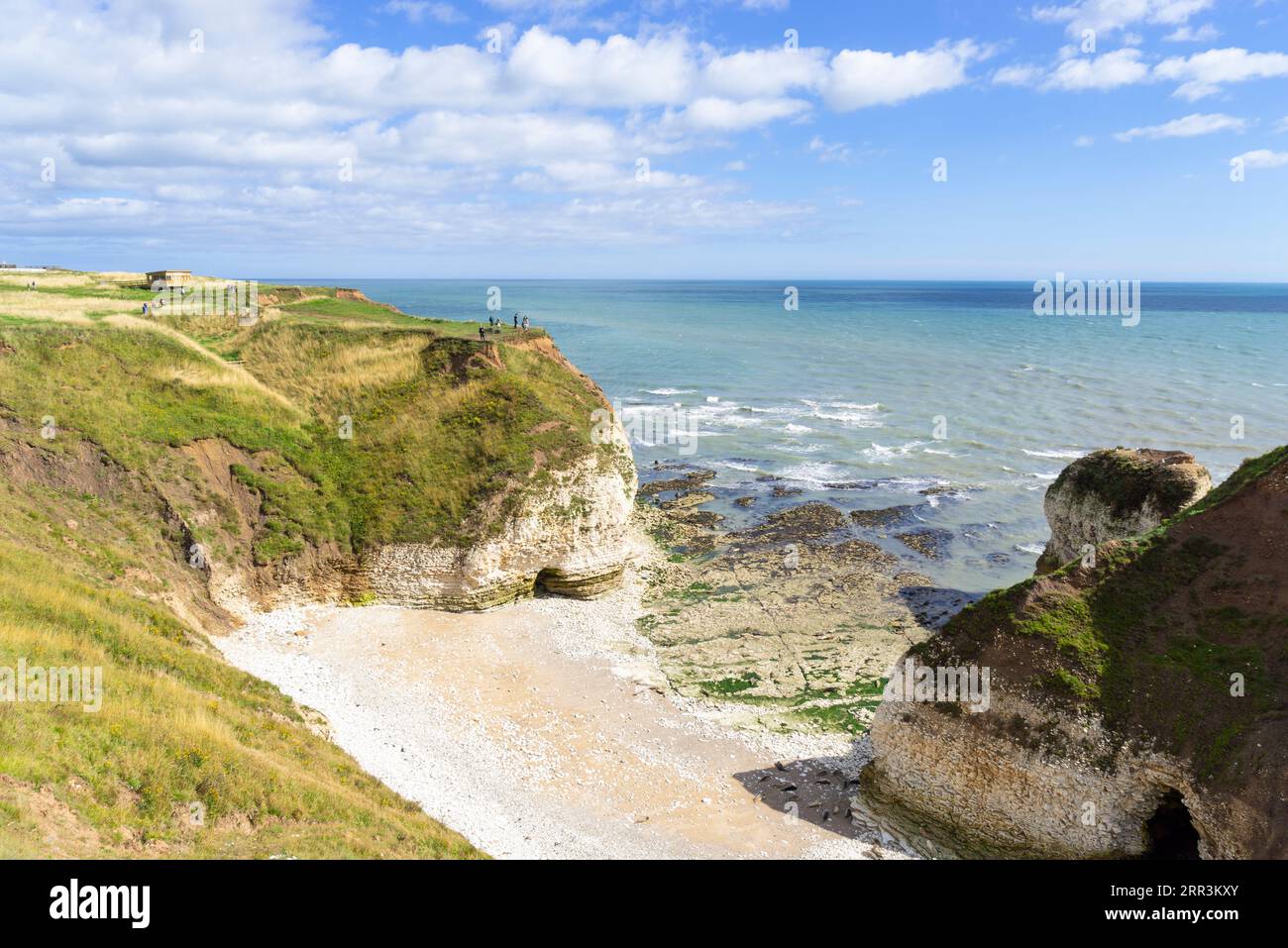 Flamborough Head with people looking at the Drinking Dinosaur rock arch Flamborough Yorkshire coast East Riding of Yorkshire England uk gb Europe Stock Photo