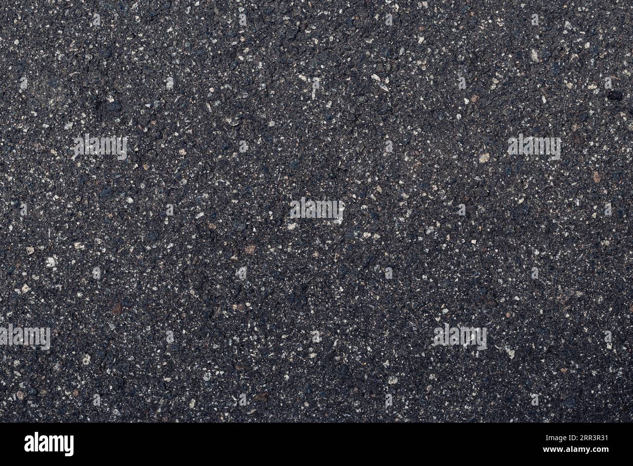 Surface grunge rough of asphalt, dark grainy road close-up, black texture background with small rocks, top view Stock Photo