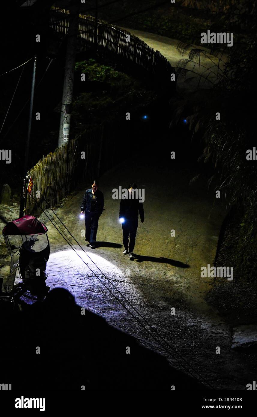 201116 -- GUIYANG, Nov. 16, 2020 -- Liu Ying L and He Changle walk to visit the home of a registered poor family at night in Dongqin Village, Congjiang County of southwest China s Guizhou Province, Nov. 11, 2020. Located in the area of the Yueliang Mountain, Congjiang County is one of the nine counties in Guizhou that still fight against poverty. After graduating from college, He Changle, joined his mother Liu Ying, became poverty relief assistant in Dongqin Village of Congjiang County at the end of 2019. In their work, they manage to solve difficulties local villagers meet including renovatin Stock Photo
