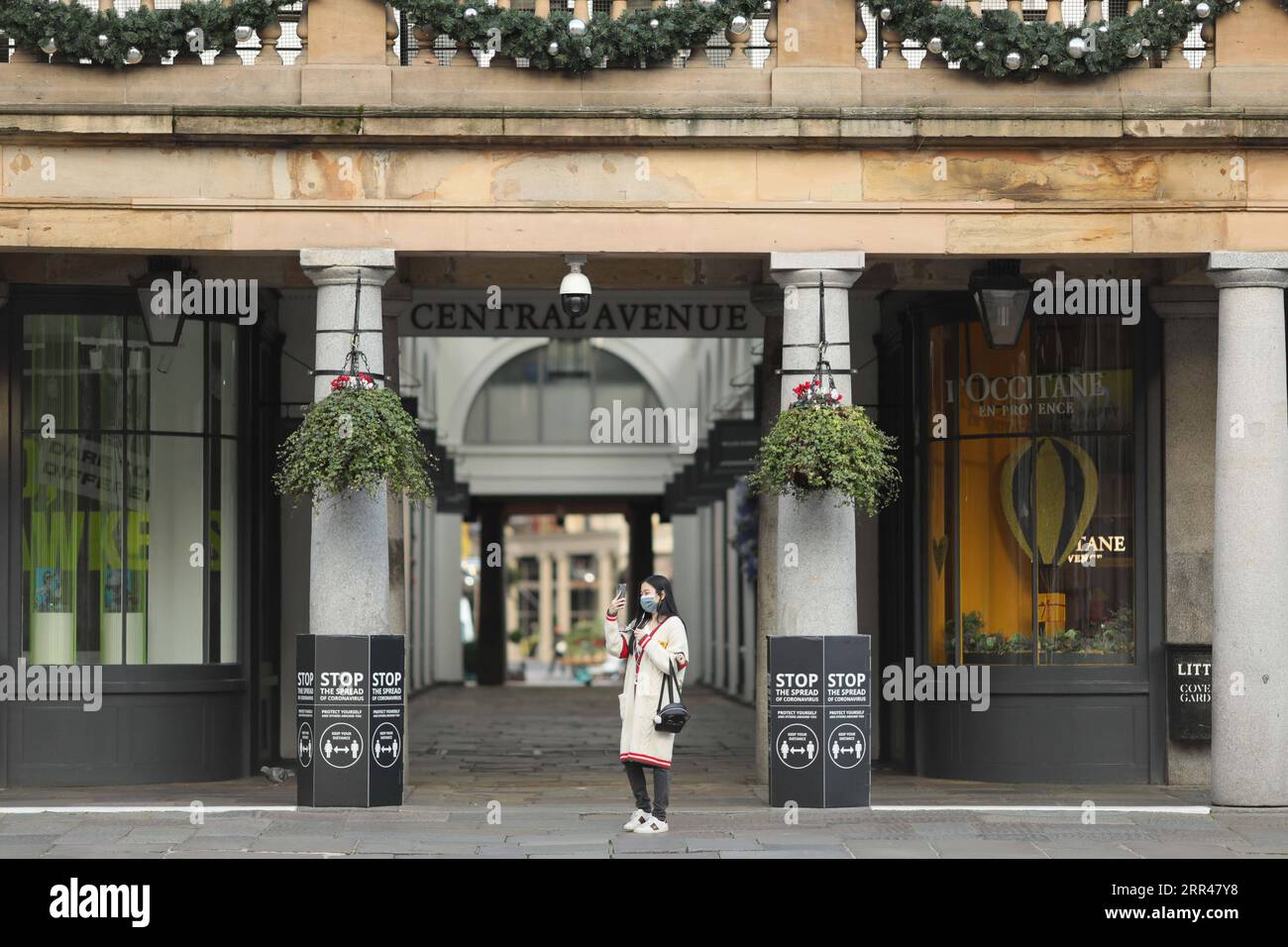 201123 -- LONDON, Nov. 23, 2020 -- A person cleans the pavement outside the  closed Chanel store on New Bond Street, in London, Britain, on Nov. 23,  2020. Another 15,450 people in