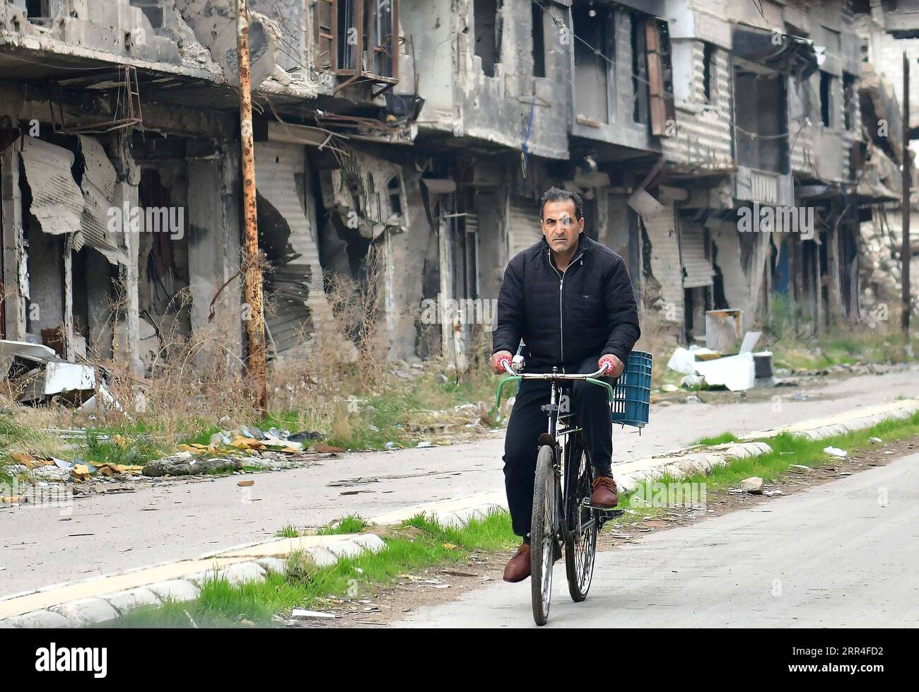 201203 -- DAMASCUS, Dec. 3, 2020 -- A man rides his bicycle in the Yarmouk Camp area, south of the capital Damascus, Syria, on Nov. 27, 2020. With mixed feelings of happiness and sadness, Jamal Hammad entered the war-ravaged Yarmouk Camp for Palestinian refugees, south of Damascus, to start a journey of returning to his old life that was scarred by the prolonged war in Syria. The 58-year-old humanitarian worker was among the first to enter the Yarmouk Camp. He climbed over the rubble and debris to reach his house, overwhelmed by the happiness of return, as well as sadness and anger about the d Stock Photo