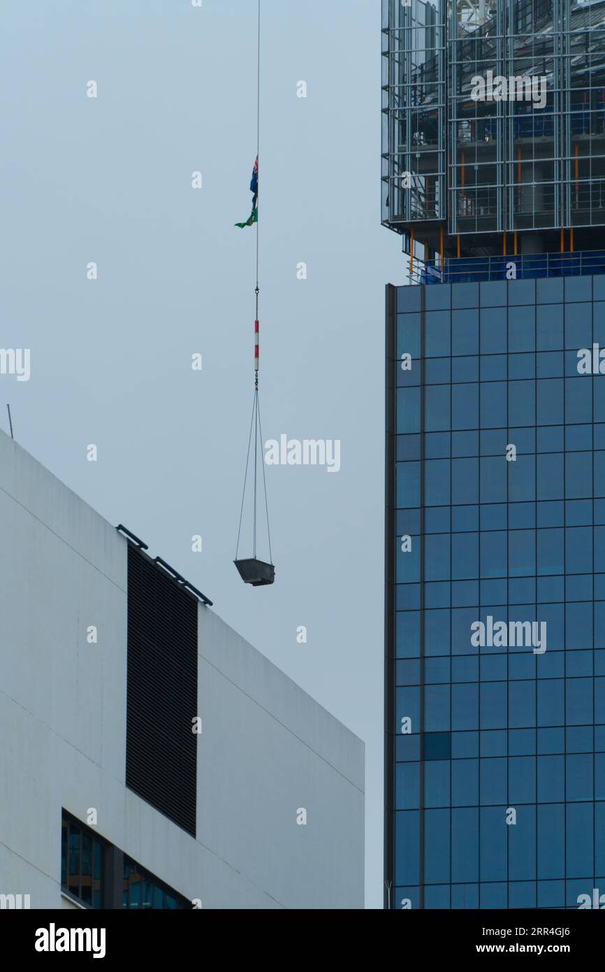 A crane lifting materials on a city construction building site in