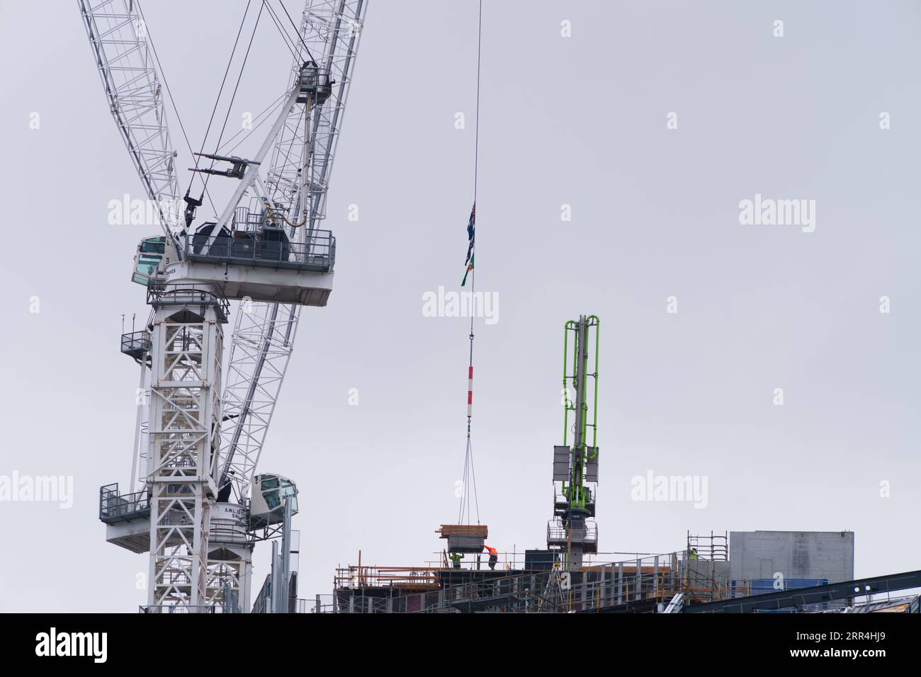 A building crane lifting construction materials on a city building site ...