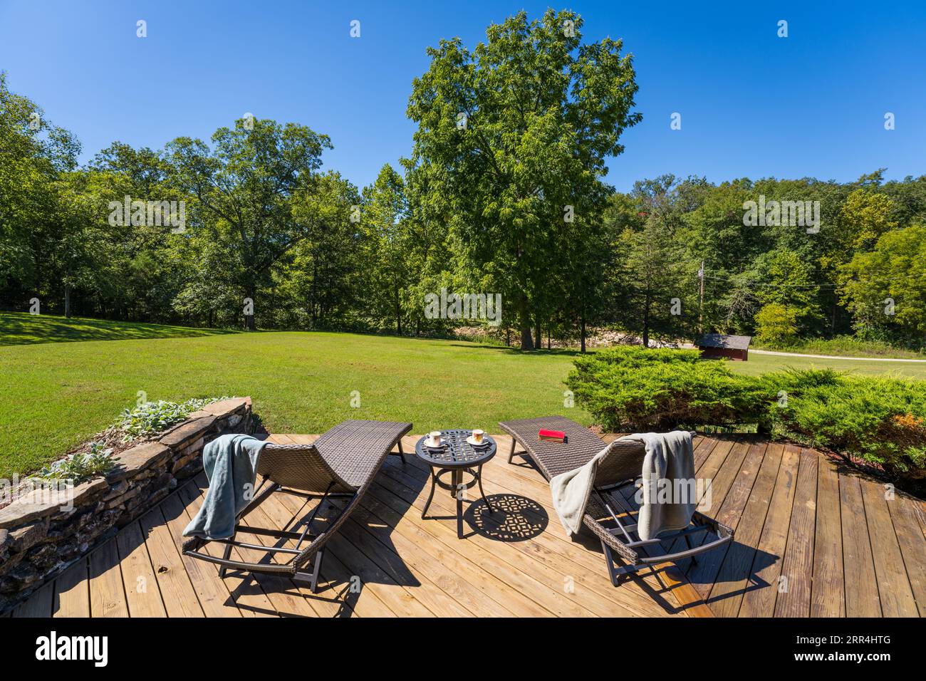 A couple of modern lounge chairs on a deck at a country home. Stock Photo