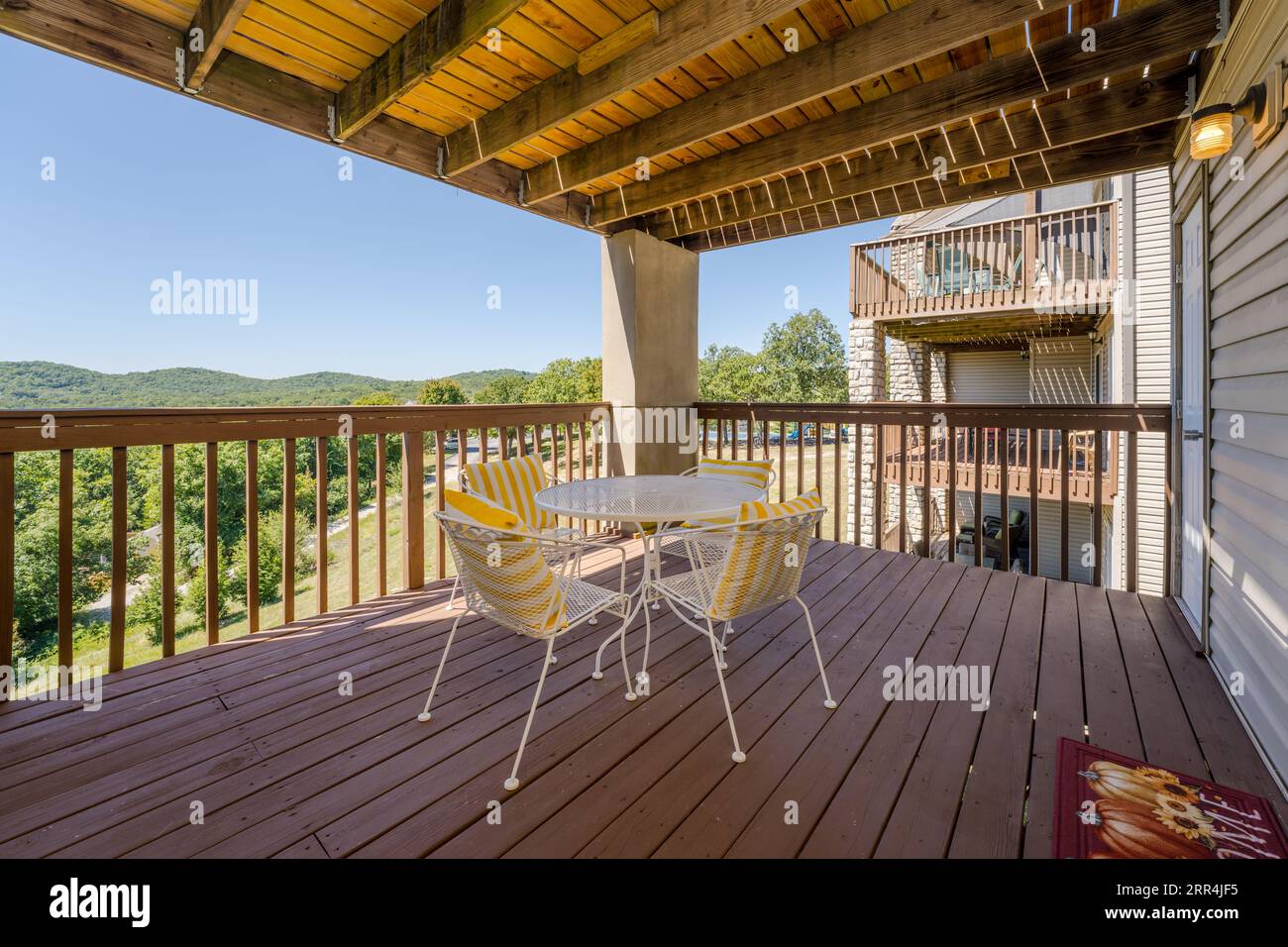 An upper level deck space with a table and 4 chairs Stock Photo Alamy