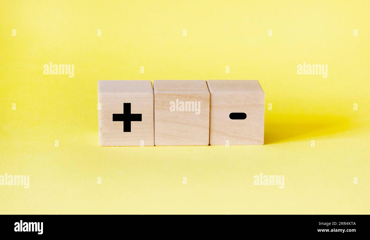 blocks on a yellow background with a plus and a minus. Choice concept Stock Photo