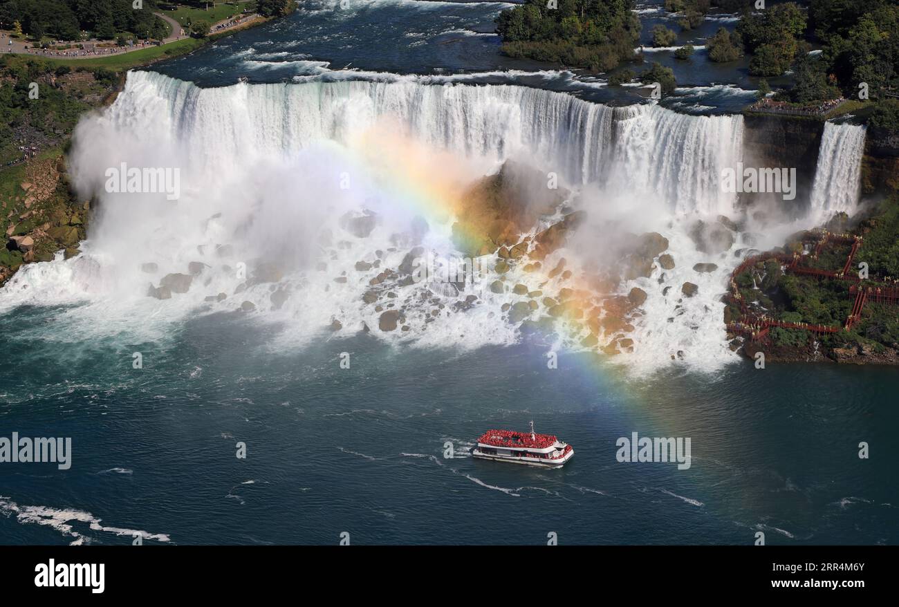 Aerial view of American and Bridal Veil Falls including the rainbow and Hornblower Boat sailing on Niagara River, Canada and USA natural border Stock Photo