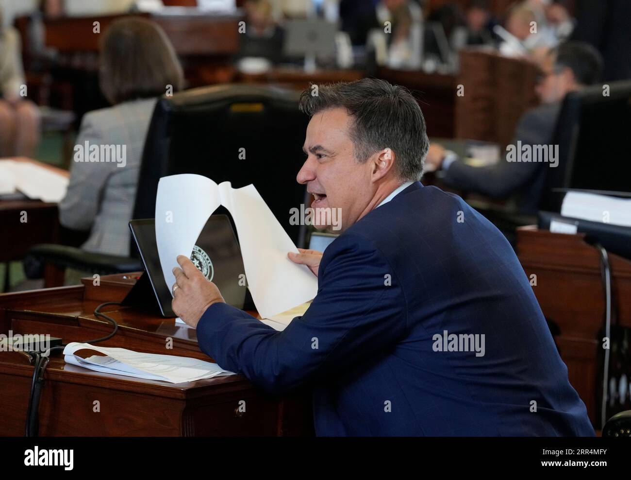 Sen. Roland Gutierrez, D-San Antonio speaks with a colleague on the motions during the morning session of Texas Attorney General Ken Paxton's impeachment trial in the Texas Senate on September 6, 2023. Credit: Bob Daemmrich/Alamy Live News Stock Photo