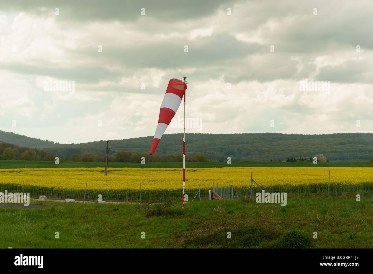A red and white wind cone indicating the direction and strength of the wind. Light wind, cone lowered. Stock Photo